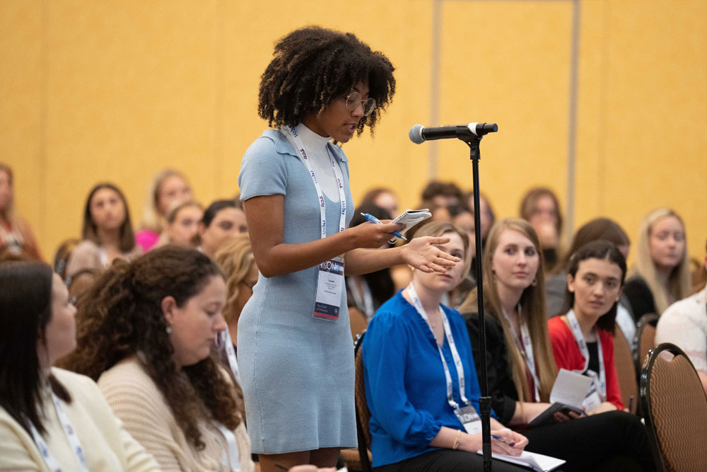 student speaking at microphone